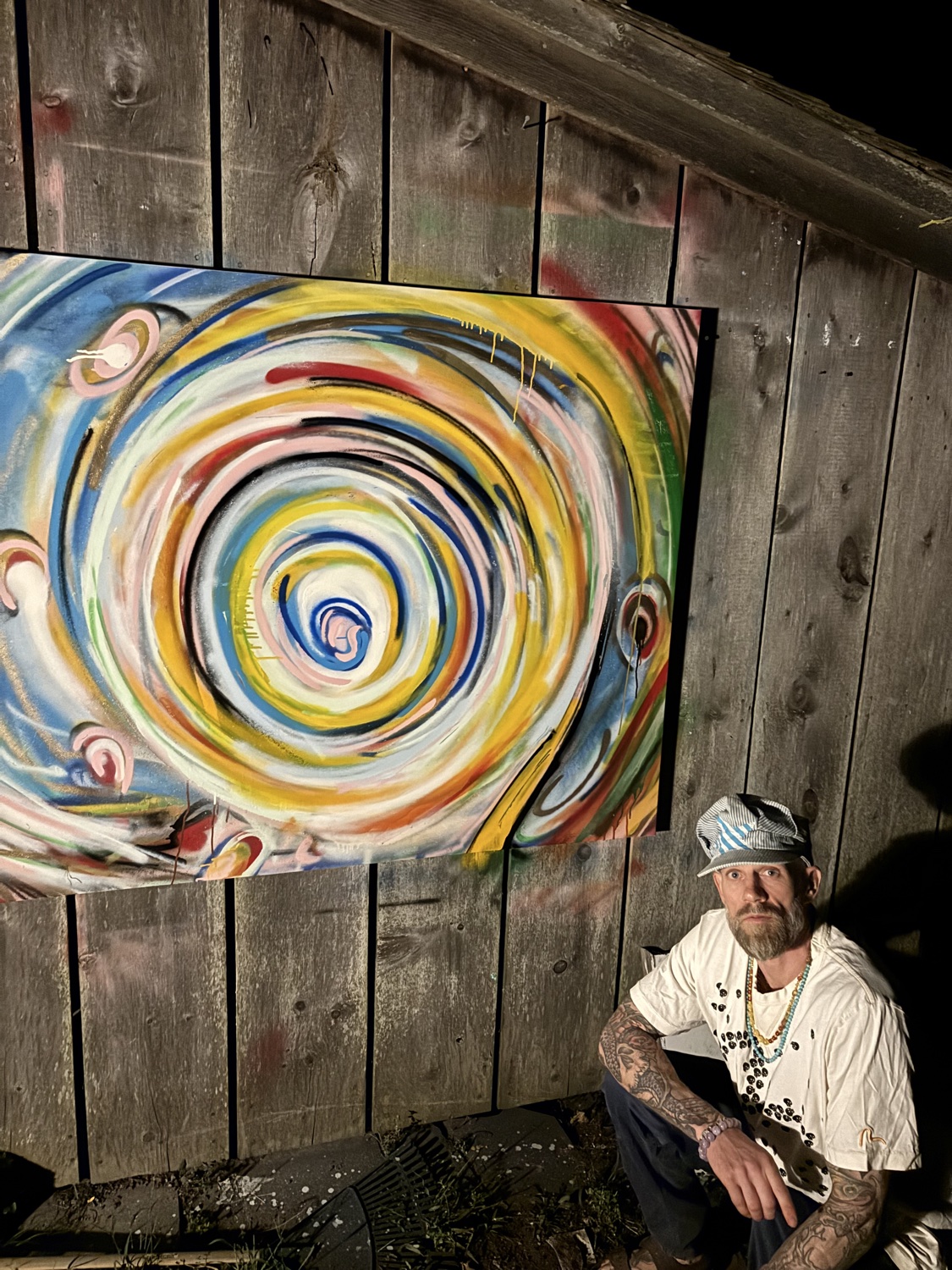 SLOW working beside a large spiral painting