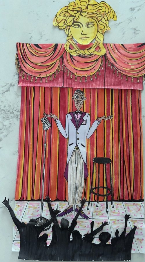 Comedian performing on stage in a paper cutout work