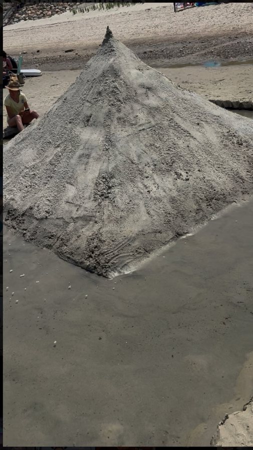 Large pyramid sculpture shaped from beach sand